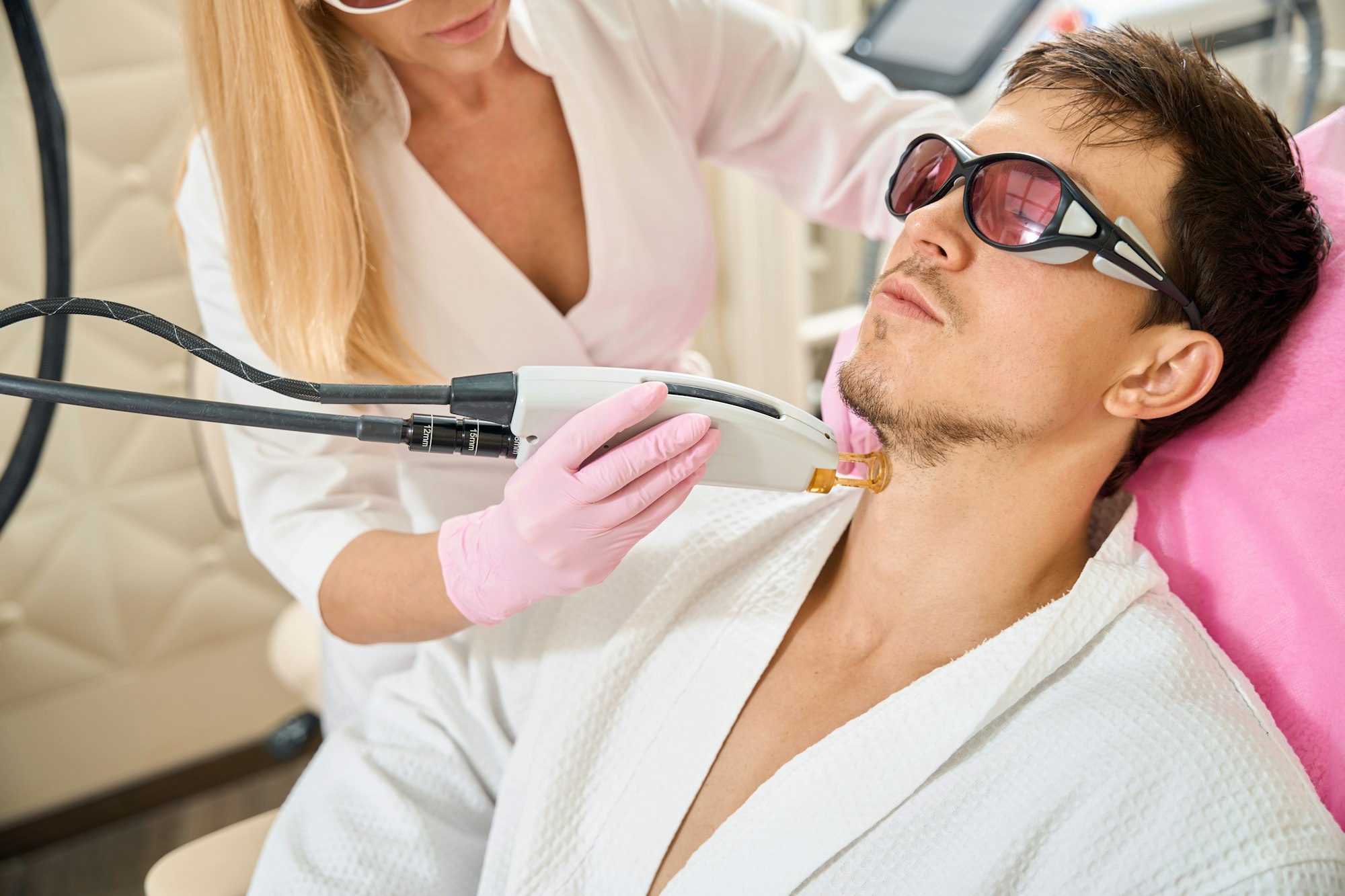 Man, client of beauty salon undergoing laser hair removal procedure
