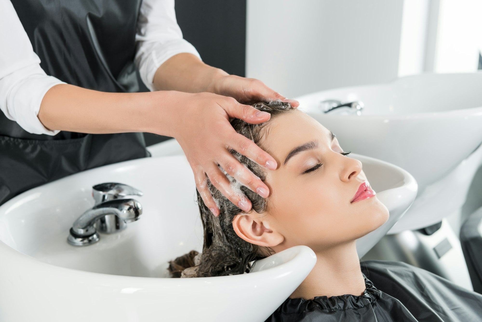 relaxed woman having hair wash in beauty salon
